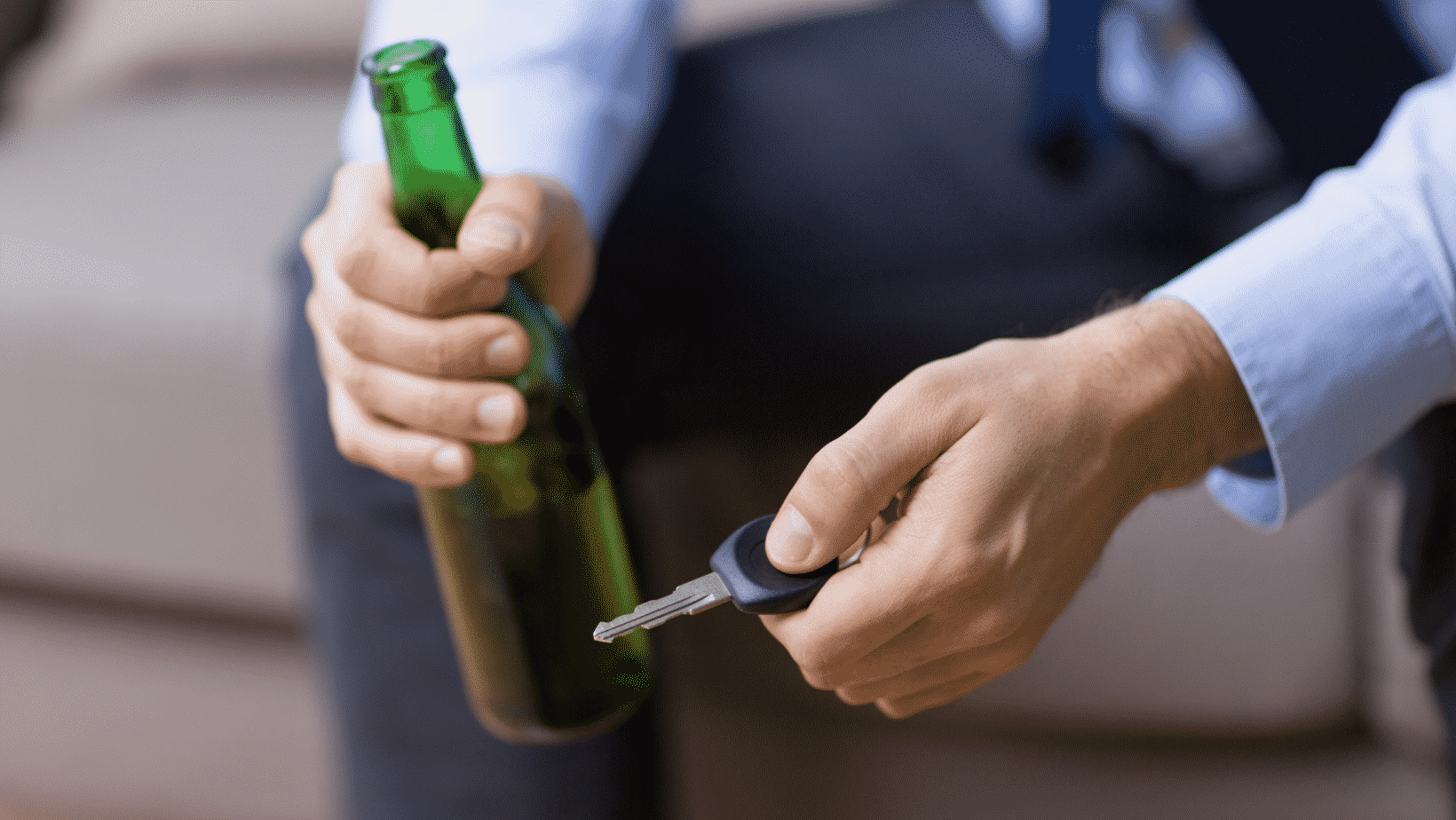 man holding alcohol while holding a car key